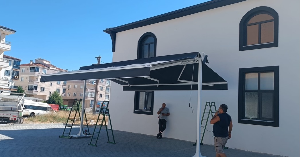 Motorlu tente montajı — siyah kumaş, duvar bağlantılı